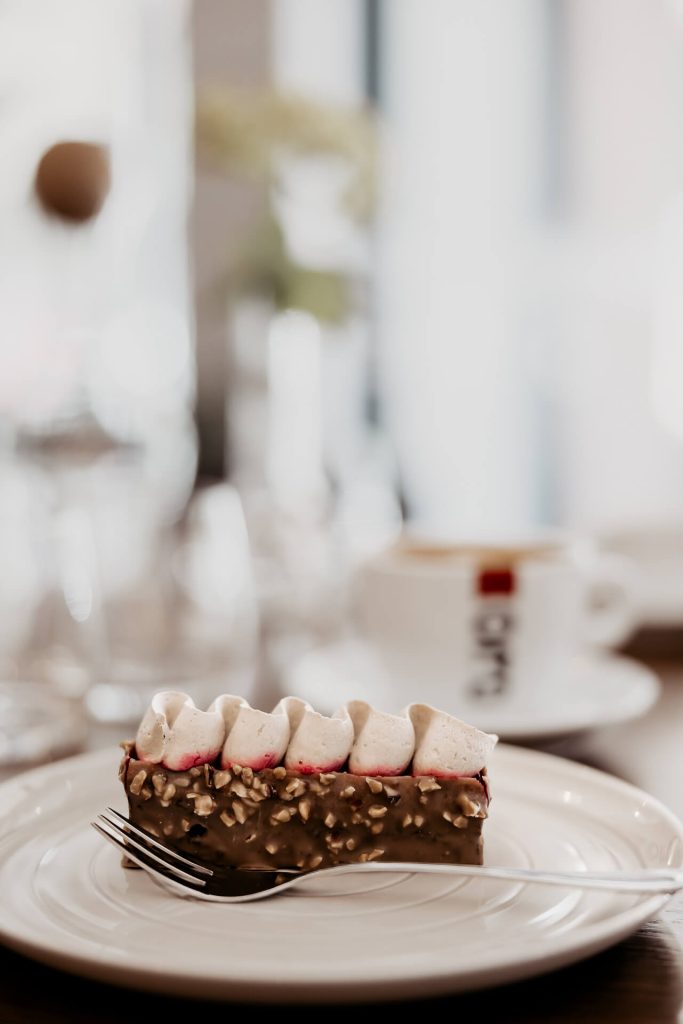 detailný záber na dezert obalovaný v čokoláde s orieškami, malinovým pyré