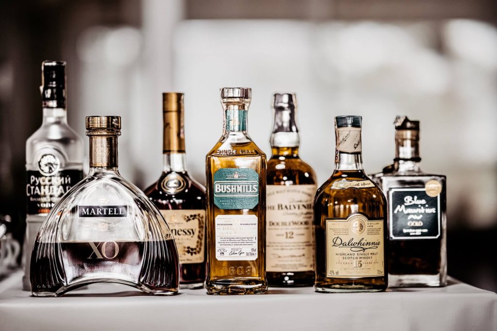fľaše kvalitného alkoholu na stole - whisky, rum, koňak