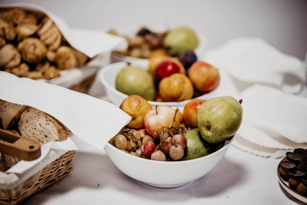 stôl s miskami rôznorodého slovenského ovocia a s košíkmi s pečivom